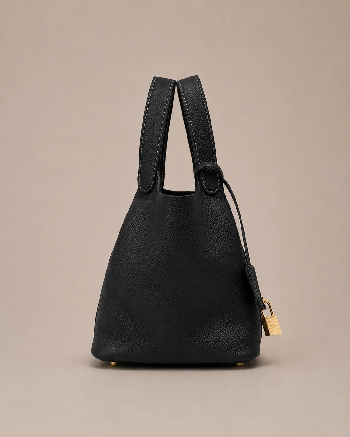 Side profile view of Scarlett genuine leather bucket tote bag in black leather with structured bucket silhouette and top handles