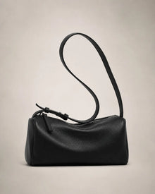 Side view of the Simone genuine leather cylindrical crossbody bag in black showing the barrel silhouette and adjustable strap.