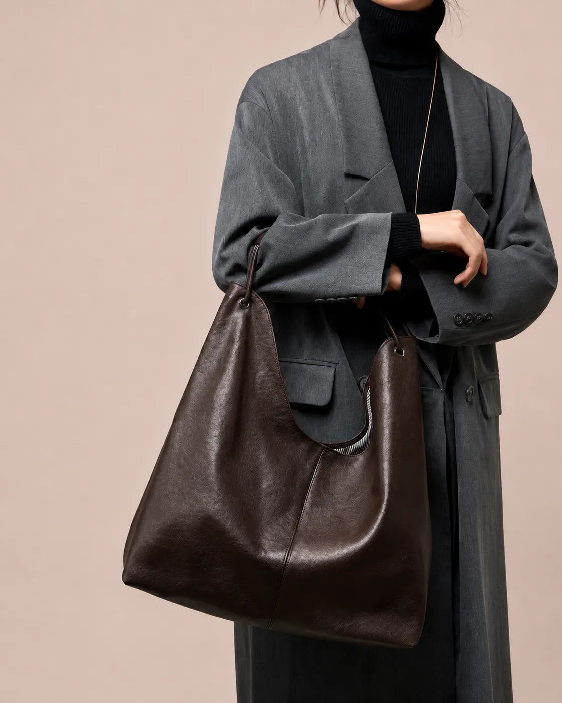 Front view of a woman carrying The Colette genuine leather hobo tote bag in Dark Chocolate, featuring a relaxed silhouette, premium leather and timeless luxury styling.