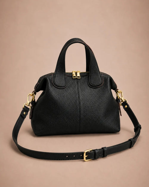 Victoire leather dumpling bag in Black genuine leather featuring a soft structured silhouette, adjustable shoulder strap, double top handles, gold-tone hardware and secure zip closure.