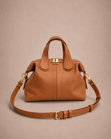 Victoire leather dumpling bag in Brown genuine leather featuring a soft dumpling silhouette, adjustable shoulder strap, double top handles, premium pebbled leather texture and gold-tone hardware.