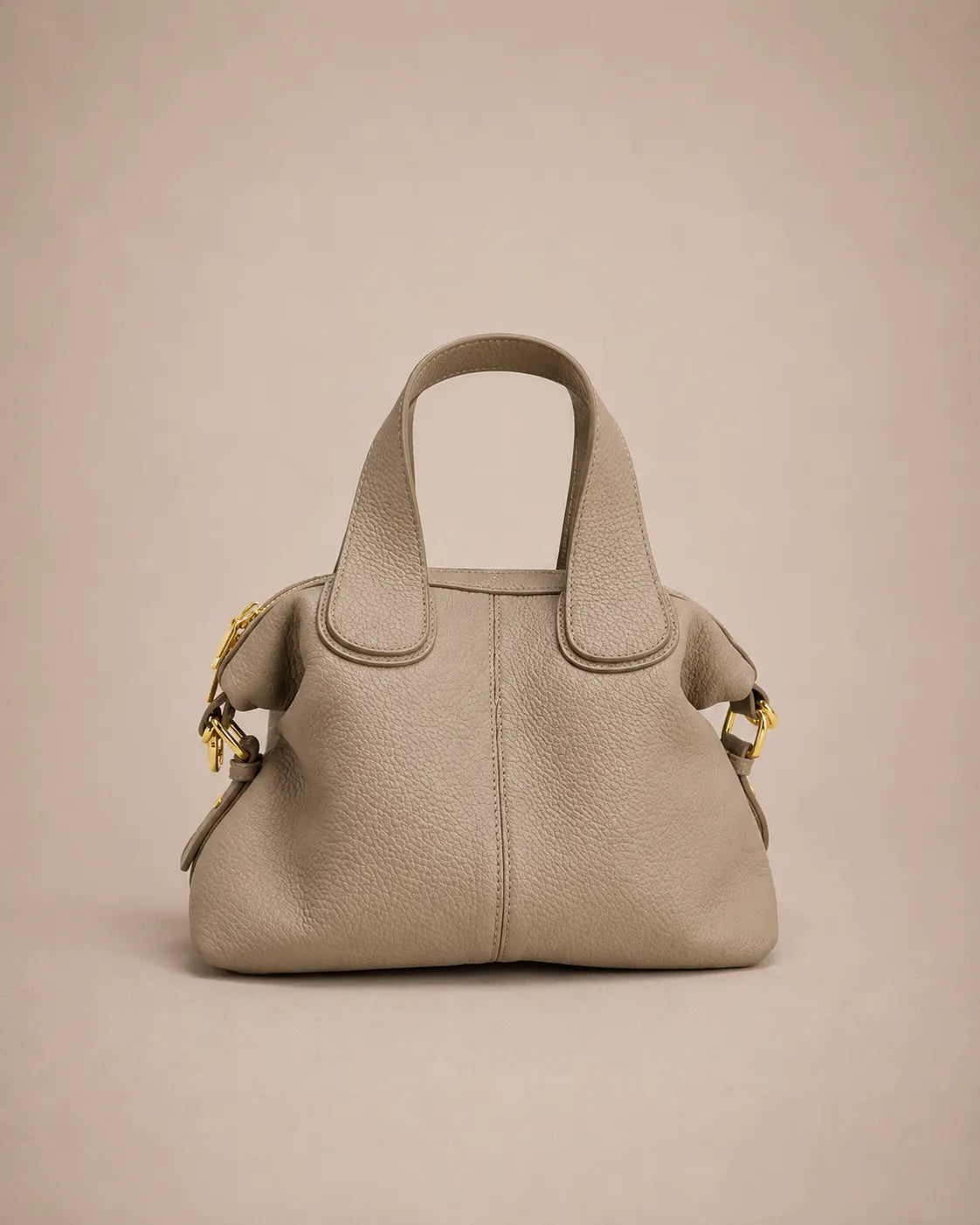 Victoire leather dumpling bag in Elephant Gray genuine leather displayed with top handles only, highlighting the elegant dumpling silhouette, pebbled leather texture and refined minimalist design.