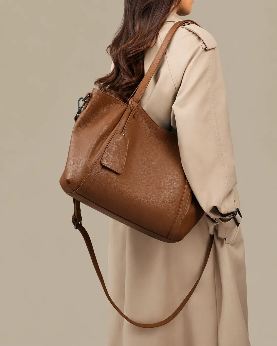Model carrying The Viney large genuine leather commuter bag in Brown with the detachable crossbody strap for versatile everyday wear.